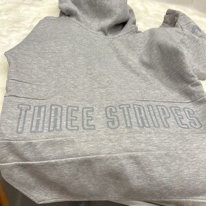 Adidas hoodie gray says three stripes on the front and the back size extra small